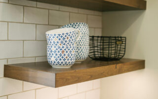 Floating wood shelf on wall with bowls in kitchen